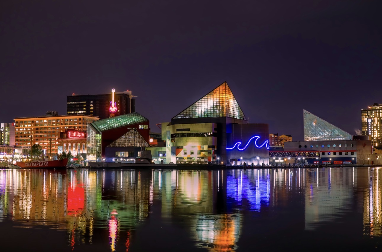 Baltimore Inner Harbor at night with colorful building lights reflected on the water